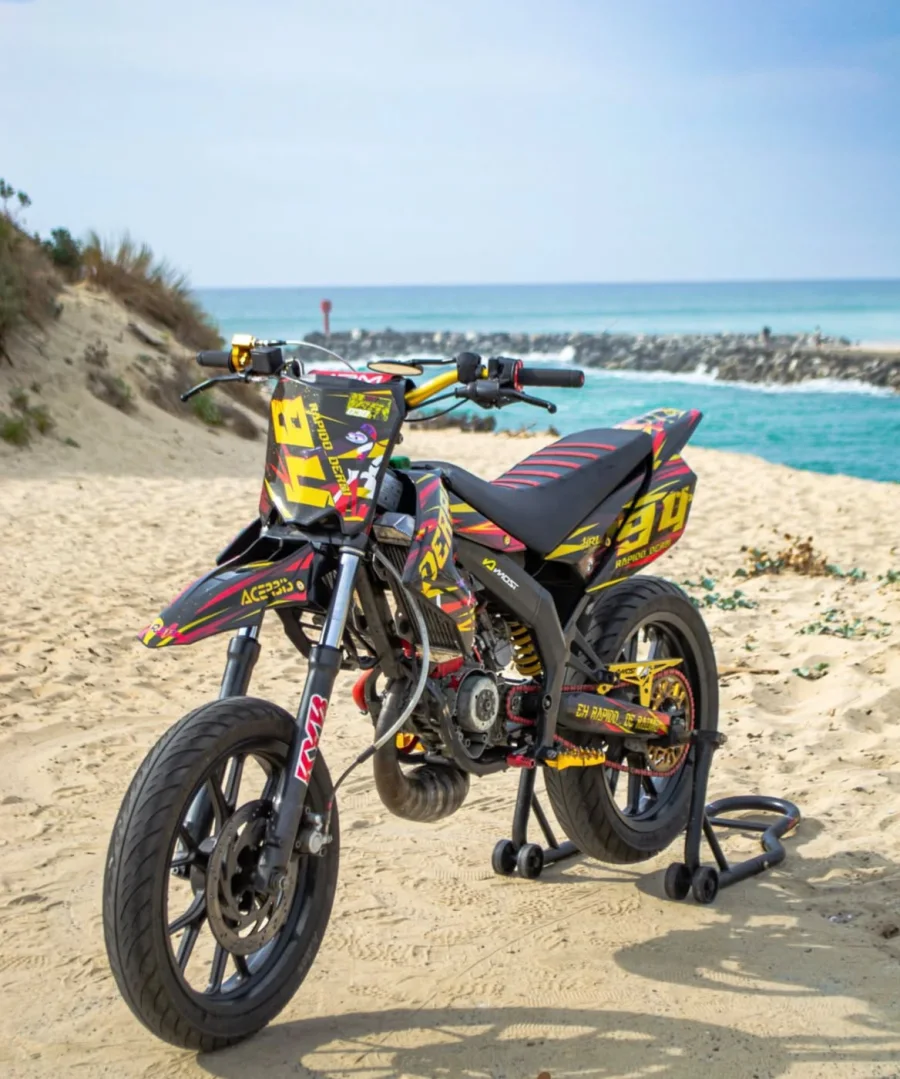 Derbi 50 cc supermotard avec kit déco HRL noir, jaune et rouge, numéro 94, sur une plage